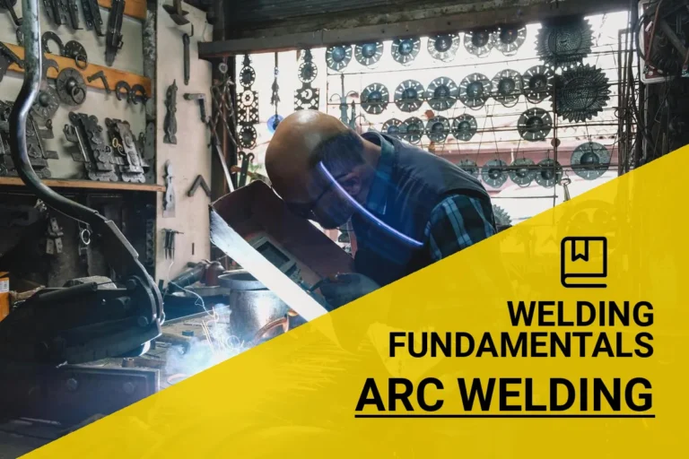 An experienced welder performing arc welding techniques in a busy workshop surrounded by tools and metal components.