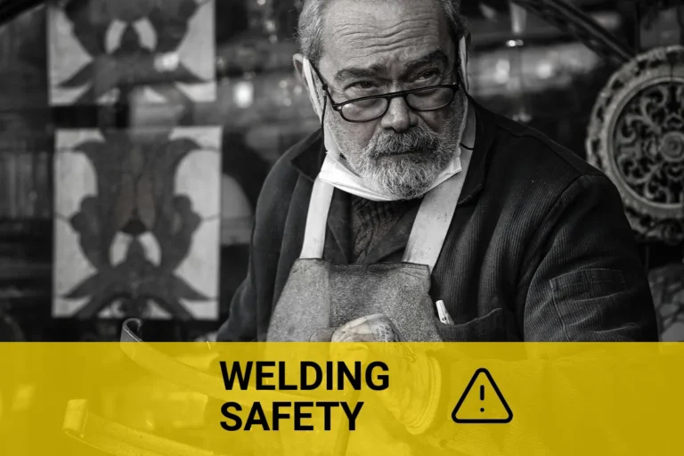 Close-up black and white image of an elderly man welding indoors, capturing the dynamic sparks flying as he expertly works on a metal project.