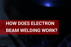 A skilled welder using electron beam welding technology, illuminated by blue light in a nighttime setting.