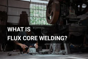 Artisan engaged in flux core welding within a well-equipped metalwork workshop, surrounded by advanced machinery.