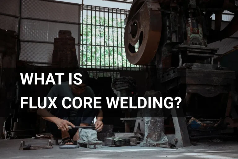 Artisan engaged in flux core welding within a well-equipped metalwork workshop, surrounded by advanced machinery.
