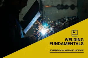 Experienced welder with a torch crafting metal components while pursuing journeyman welding license in a professional workshop.