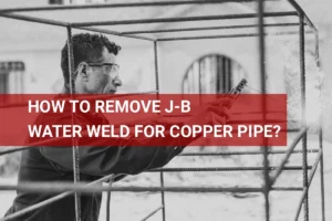 Close-up image of a welder removing J-B Water Weld from a copper pipe in a workshop setting.