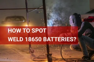 Close-up of a technician performing spot welding on 18650 batteries, with sparks illuminating the industrial workshop at night.