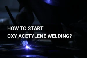 Close-up of an artisan initiating oxy acetylene welding in a low-light industrial setting.