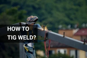 Construction worker demonstrates how to TIG weld on a steel beam at a construction site, equipped with safety gear and helmet.