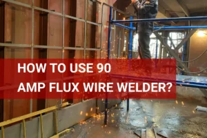 A construction worker operates a 90 amp flux wire welder indoors, producing sparks while welding metal in a factory environment.