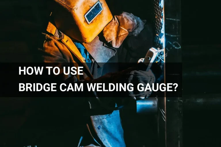 A welder using a bridge cam welding gauge in a dimly lit industrial setting, ensuring precision and safety while working with metal.