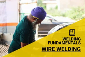 An elderly craftsman in a turban expertly demonstrates how to wire weld metal outdoors, showcasing his skilled craftsmanship with professional tools.