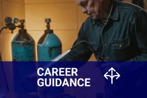 A journeyman welder skillfully using a welding torch in a metal workshop, surrounded by gas cylinders and welding equipment.
