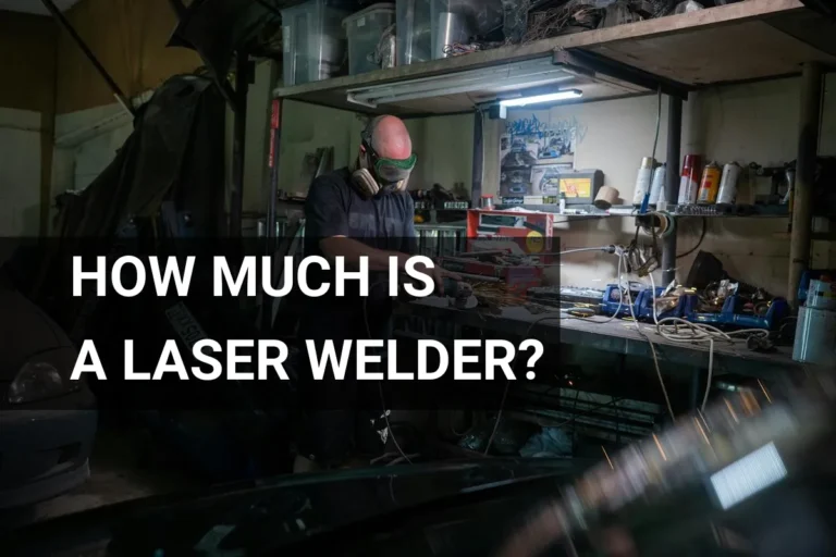 Mechanic wearing safety gear operates a laser welder for precision metal fabrication in an industrial garage.