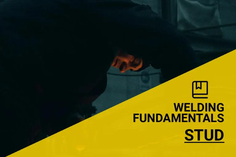 A skilled worker performs stud welding in a dimly lit industrial workshop, focusing on precision and quality in metal joining.