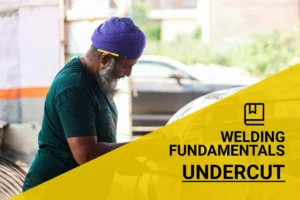 Elderly man with turban expertly demonstrating an undercut in welding metal in a workshop, showcasing skilled craftsmanship and precision techniques.