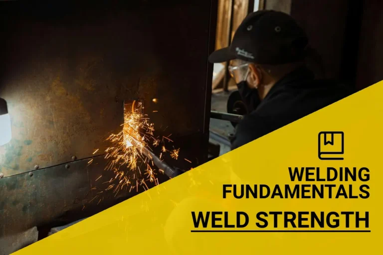 A welder assessing the strength of a weld in a workshop, measuring how much weight it can hold.