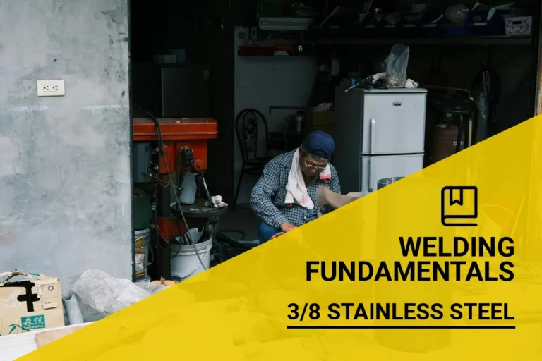 An adult man using a welder to join 3/8 stainless steel in a garage filled with tools, demonstrating the required amps for effective welding.