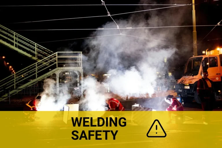 Welders in protective gear working on a city street at night, showcasing the importance of eye safety to prevent welding-related eye injuries.