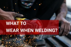 Safety gear for welding: a person in protective clothing and helmet working on metal, surrounded by bright sparks.